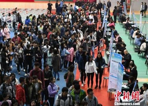 资料图:众多大学生扎堆招聘现场求职。杨华峰 摄