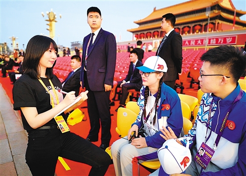 经济日报·中国经济网记者姜天骄（左一）在庆祝中华人民共和国成立70周年大会现场采访。