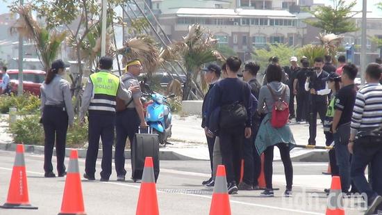 台湾退警协会执行长陈志杰拿着大声公(扩音器)被警力劝离。(图片来源:台湾《联合报》)