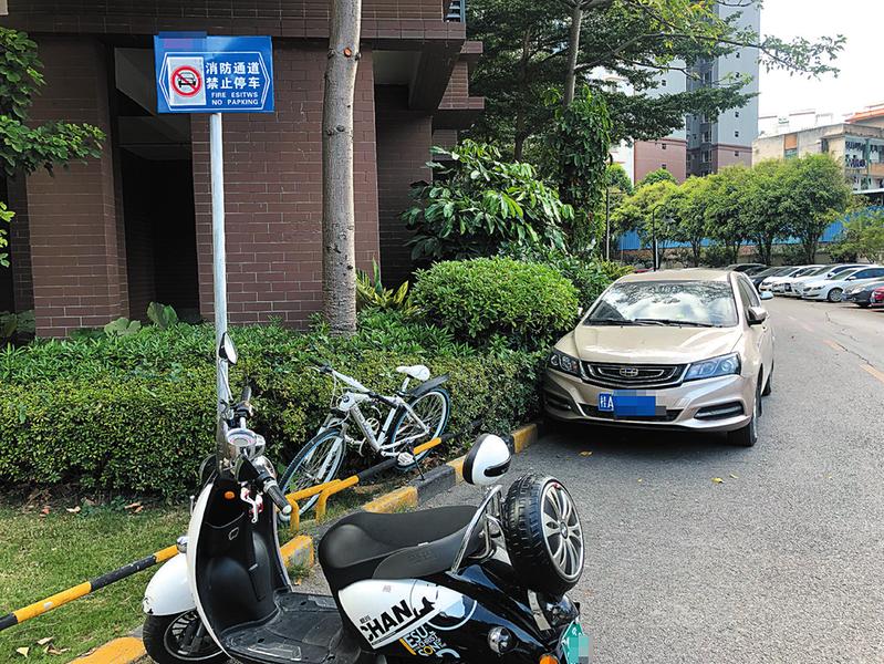 明秀路某小区消防通道上有禁止停车的警示牌,仍有电动自行车和小车停在这里 记者宋延康摄