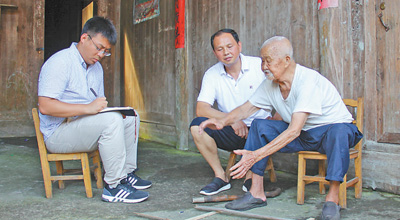 105岁的支义青老人(右一)正在讲述帮红军架设浮桥的过程。本报记者 邝西曦摄