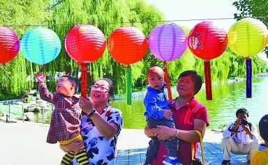 9月24日，游客在北京玉渊潭公园内猜灯谜。樊甲山摄 光明图片/视觉中国