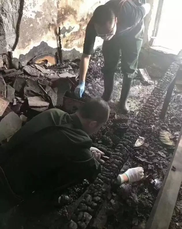 工作人员正在检查被烧毁的湘绣作品。