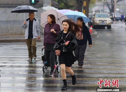 资料图:民众在雨中出行。中新社记者 杨可佳 摄