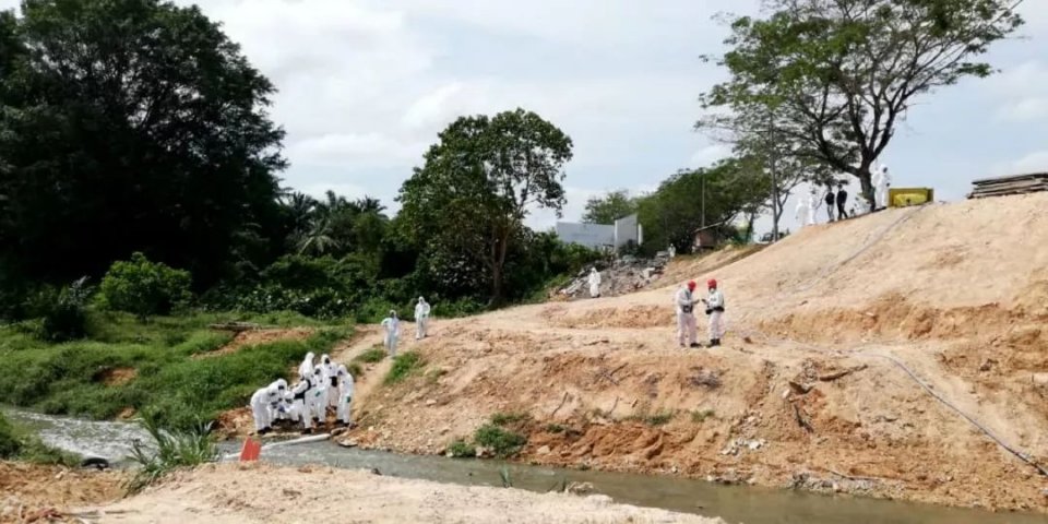 3月13日,在马来西亚南部柔佛州巴西古当地区,环境部门工作人员在河流处取样。新华社发