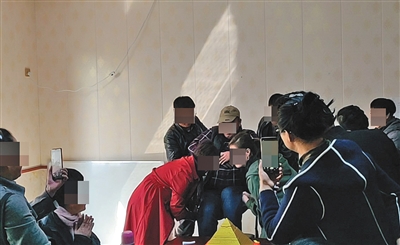 3月28日，威海瑞宏办公楼内，主持人演示用手指“抬人”实验，证明“金字塔能量”瞬间使人体重变轻。A10-A11版摄影/新京报记者 陈奕凯