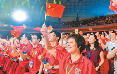 9月7日，粤港澳大湾区职工庆祝中华人民共和国成立70周年暨澳门特别行政区成立20周年文艺汇演在广州中山纪念堂上演，演出由广东省总工会、香港工会联合会、澳门工会联合总会联合主办。图为现场观众挥动五星红旗，合唱《我和我的祖国》。　　中新社记者 陈骥旻摄