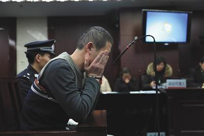 1月11日,在北京三中院开庭审理时,被告人张某捂脸痛哭。新京报记者 王飞 摄