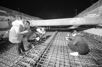 深夜地下管廊工地冷似铁， 忙碌的工人脱掉外套还说热