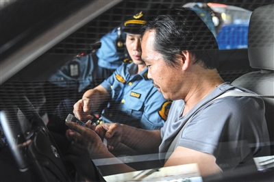 去年5月,广州市交通委员会执法局执法人员在广州东站对网约车相关资质进行核查。资料图片/视觉中国