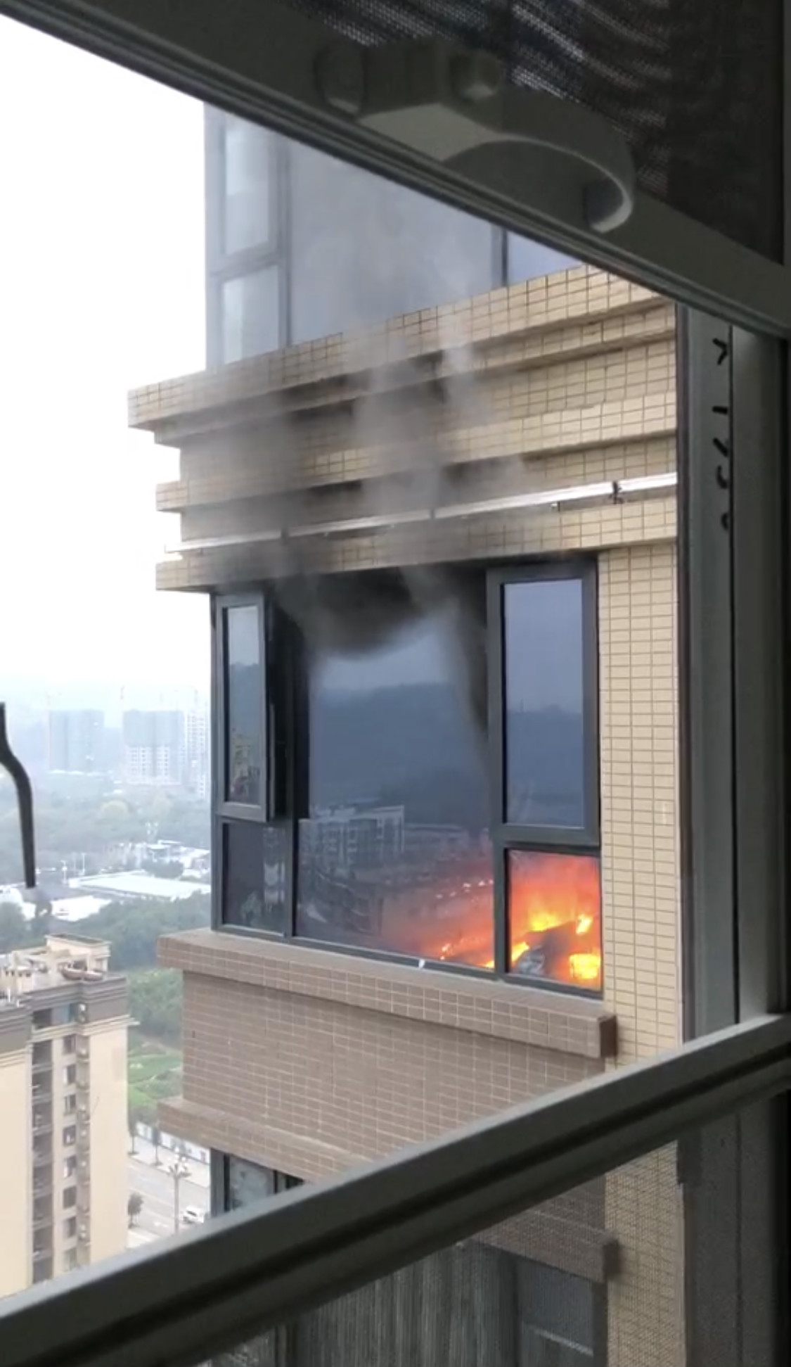 涉事房屋内有火光并伴随浓烟。 视频截图