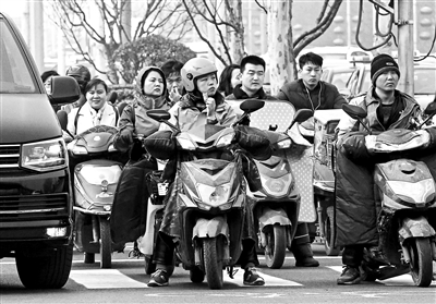 在大山子桥十字路口,谷小芳在等红灯的空隙吃着油条