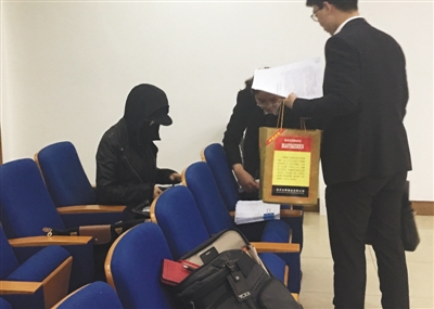严密包裹着面部的原告王女士(左一)坐在法庭旁听席上参与庭审。新京报记者 左燕燕 摄