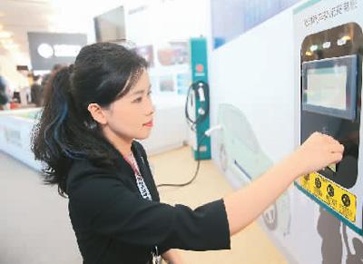 5月10日，工作人员在上海举行的首届品博会国家电网有限公司展区演示使用电动汽车交流充电桩。新华社记者 丁 汀摄