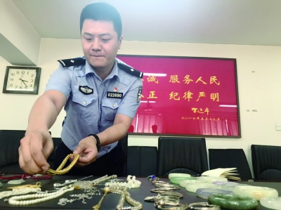 ▲民警整理从嫌疑人张某家中起获的被盗物品 摄/朱健勇