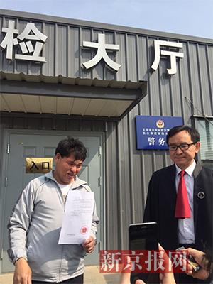 宣判后,刘忠林在律师与姐夫的陪同下走出法庭,向媒体出示无罪判决书。新京报记者王巍 摄