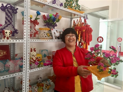 刘春燕在手工作坊,展示自己的作品。