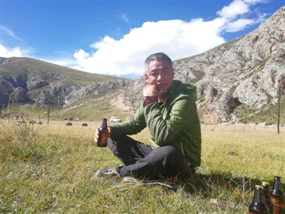 坐在可可西里的草地上，手里拿着一瓶啤酒，陈岩说，“在高原上需要喝一点酒”。
