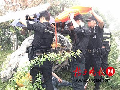 暴雨中特警为受伤群众撑起"盾牌伞"