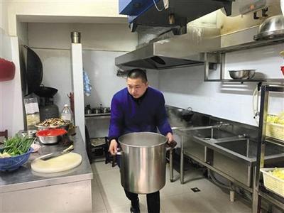 杜军现在打两份工,上午在汉口水塔街华中社区食堂做事,下午送外卖。受访者供图