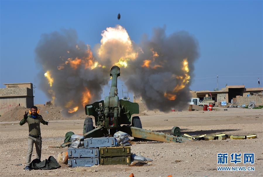 资料图：伊拉克“人民动员组织”成员向“伊斯兰国”武装分子发射炮弹。新华社路透