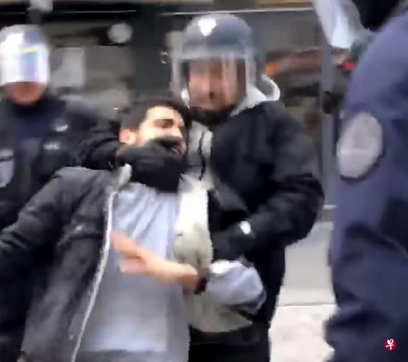 (法国总统马克隆私人保镖贝纳拉被网友拍下头戴警察头盔将一名示威者拖走 图片来源：《联合早报》)