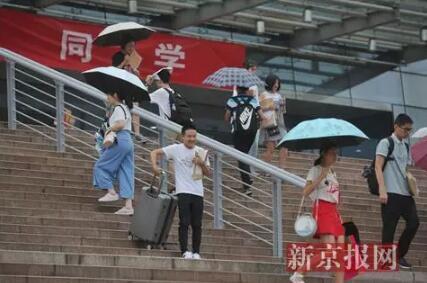  ▲8月30日，北京大学新生与家长们冒雨到学校报到。图片来源：新京报