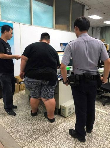 吴某(中)被通缉1年多,警方逮捕时用脚镣才把他带回警局。台湾《联合报》记者徐白樱/翻摄