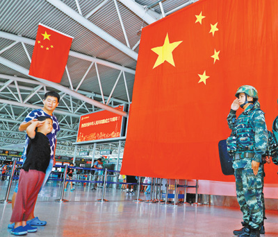 10月4日，在海南三亚凤凰国际机场，一名小朋友向坚守岗位的武警战士敬礼。 　　雷 辙摄（人民视觉）