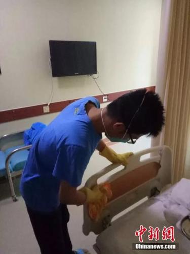 李长清在为妈妈的病床消毒。