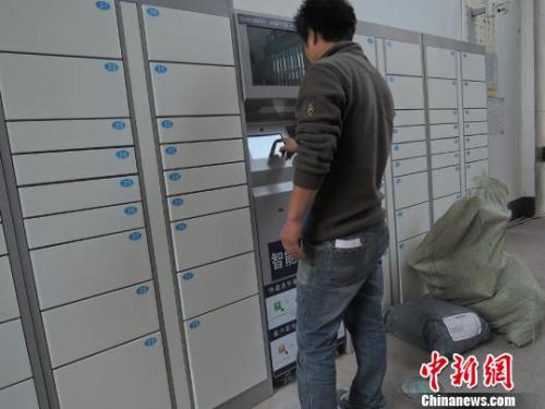 资料图:快递员使用智能快递柜投送包裹。韩章云 摄