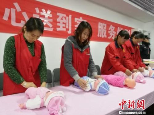 资料图:护工练习护理婴儿。 李娜 摄