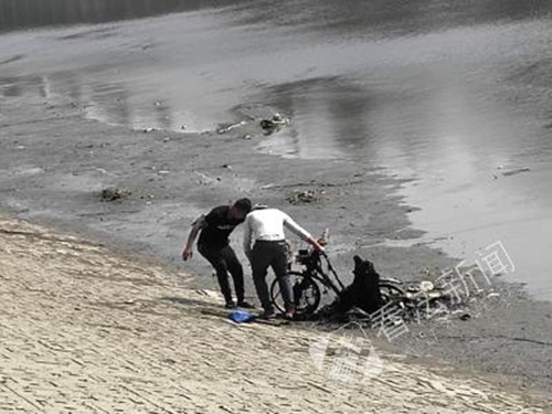 两人正在河里打捞自行车。摄/记者 董振杰