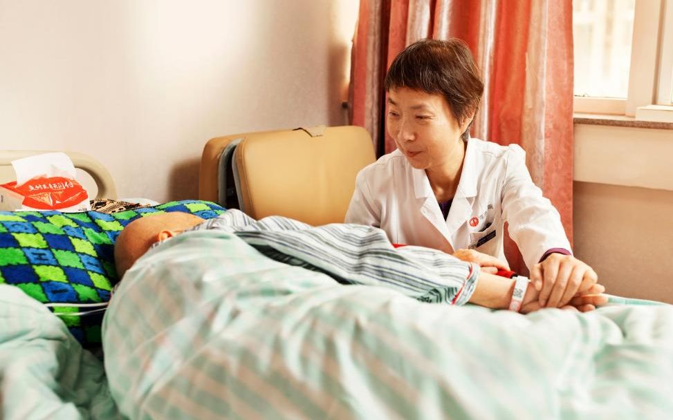 北京海医院安宁疗护病房主任秦苑在看望一位患者。受访者供图