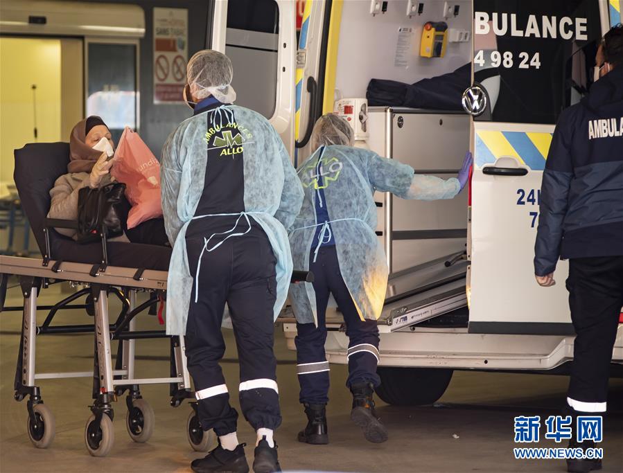  在法国北部城市里尔的罗歇·萨朗格罗医院，医护人员从一辆救护车上转移患者。（图片来源：新华网）