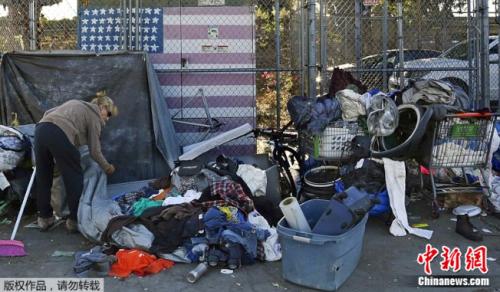 加州房价高涨，约有13.4万人没有住处。图为一名以圣地亚哥街头为家的妇女正在整理她的物品。