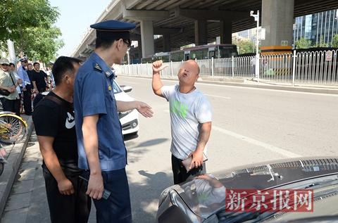 一名涉嫌驾驶车辆逆行以及非法载客的司机向执法人员辩解。