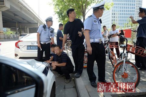 执法人员控制两名名涉嫌非法载客的司机。新京报记者 吴江 摄