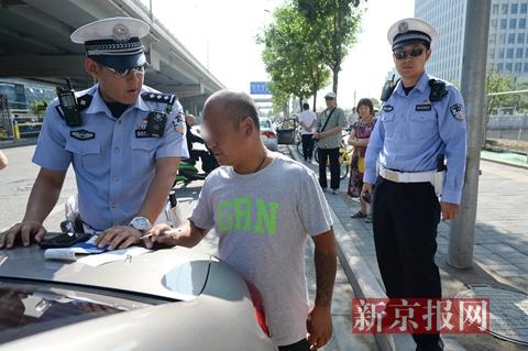 一名涉嫌驾驶车辆逆行以及非法载客的司机在处罚单上签字。