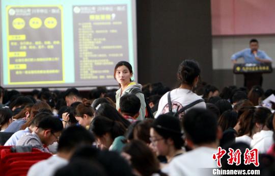 两个女孩在拥挤的教室里寻找座位。 张道正 摄