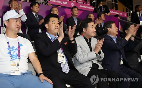 当地时间8月20日上午，在印尼雅加达，李洛渊（居中）与金一国（左二）一同观看韩朝女篮联队比赛。（韩联社）