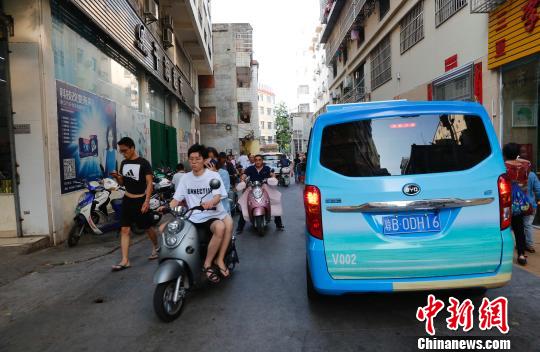 行走小巷的微公交车。 王晓斌 摄