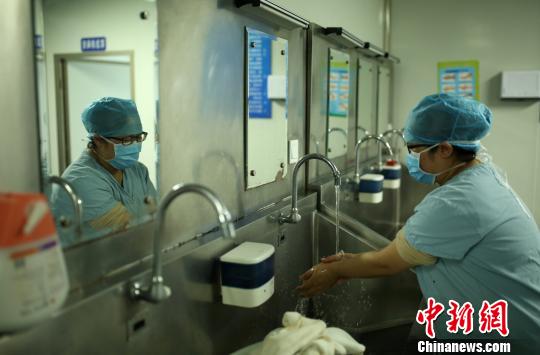 3月8日上午,在贵州省丹寨县人民医院手术室,做完三个小时的鼻息肉切除手术后的王洪梅在洗手。 黄晓海 摄
