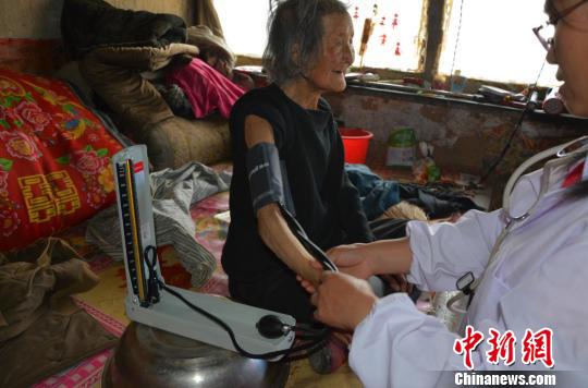 为范润全之母91岁高龄老人陈改桃测量血压。 牛全生 摄
