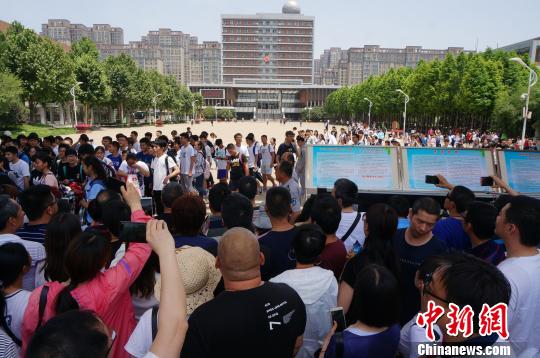 图为郑州一考点送考的家长。 韩章云 摄 郑州市教育局辟谣高考学生“撕衣赶考”:着装不符