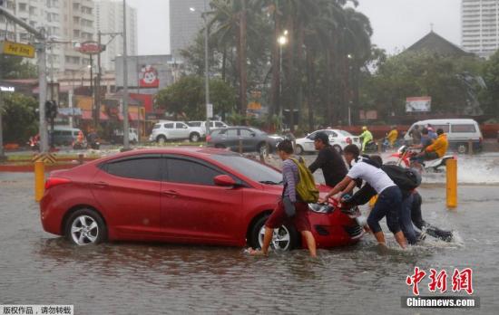 台风“山竹”肆虐菲律宾，导致汽车在水中抛锚，民众推车。