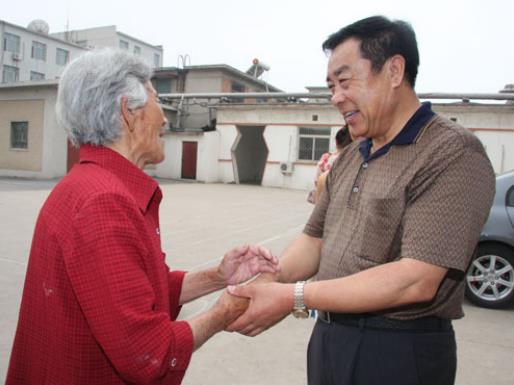 2010年6月29日，周恩义慰问渤海街道测井社区老党员。来源：东北新闻网