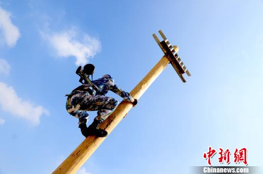 攀爬通信线杆。 尚文斌 摄