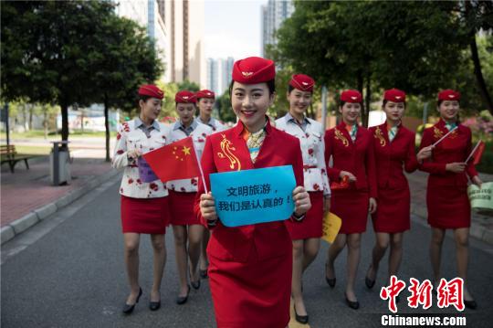 一名女生手上举着“文明旅游我们是认真的”标语。 钟欣 摄