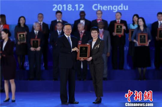 图为教育部副部田学军(左)为全球先进孔子学院颁奖。大连外国语大学校长刘宏(右)代表大外上台领奖。(大连外国语大学供图) 杨毅 摄